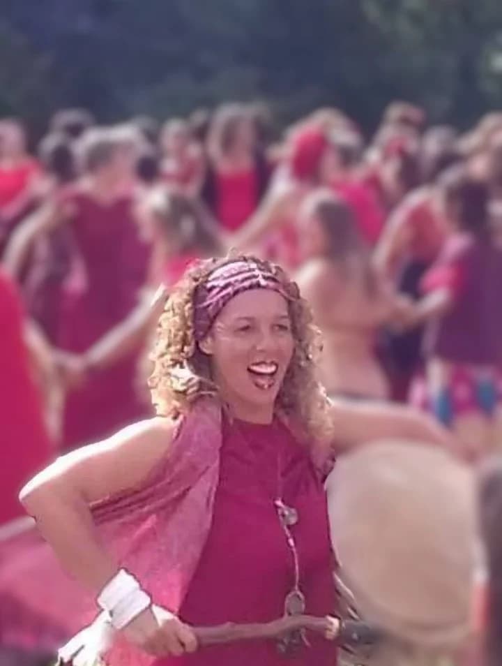 Djamila au tambour lors d’un festival féminin, dans une ambiance rouge chaleureuse